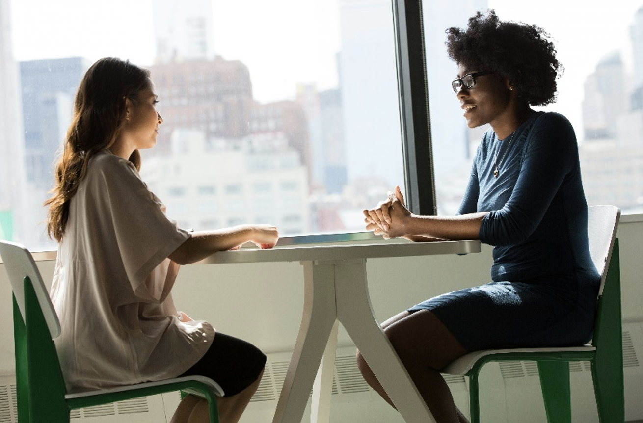 Two women sitting at a table talking